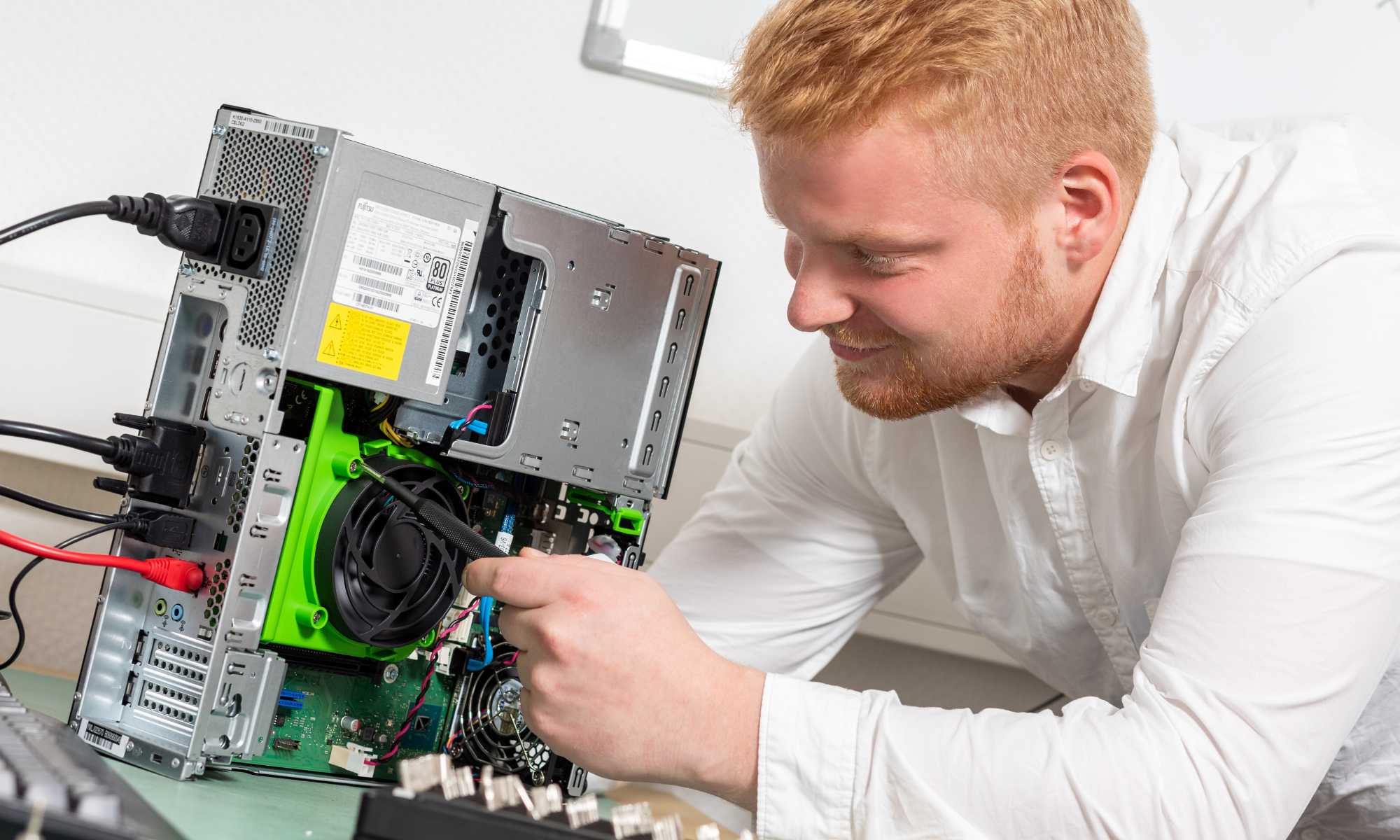 Zu sehen ist der IT-Techniker von esposito IT Justin Holland, wie er einen PC repariert.