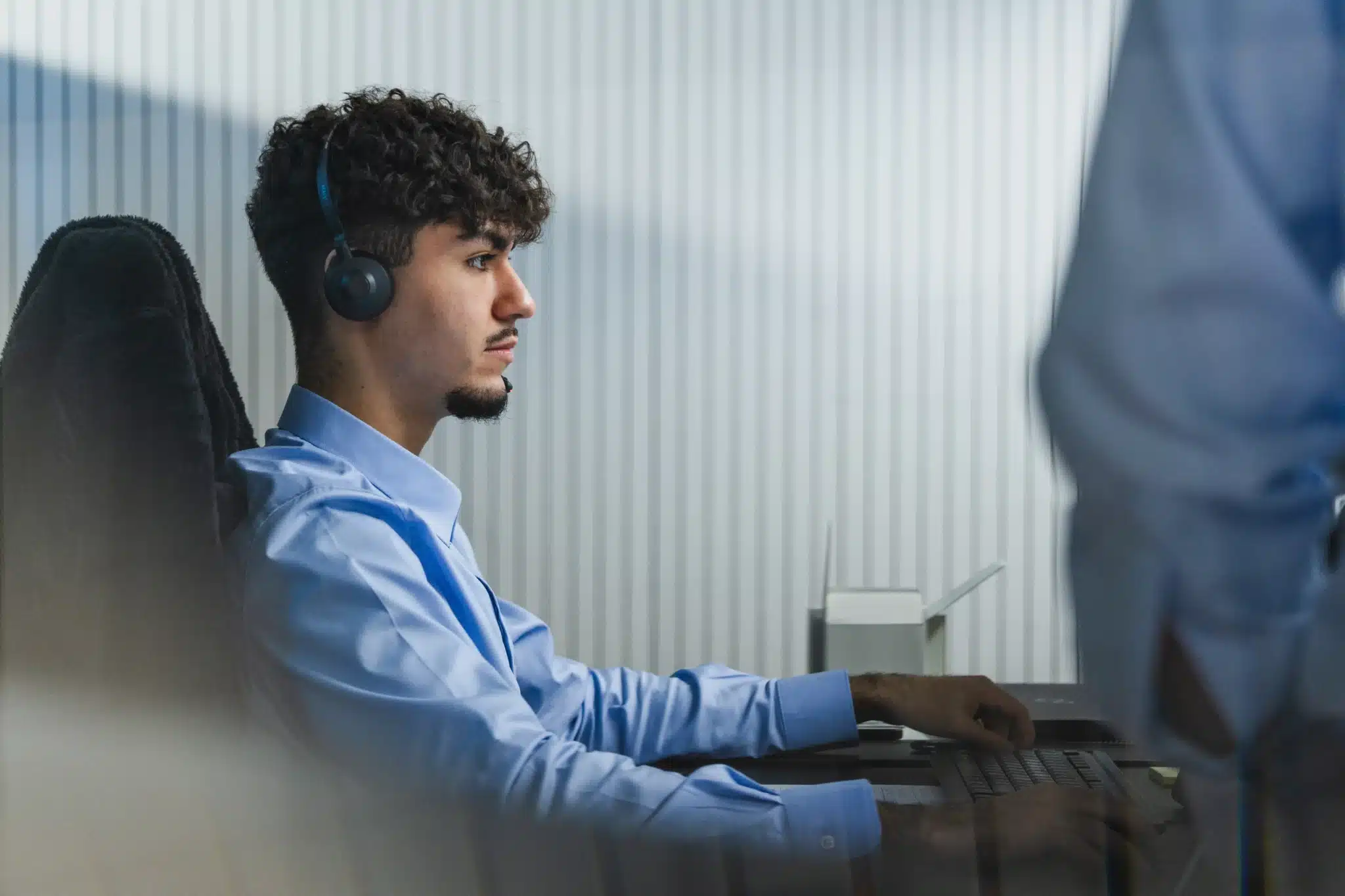 IT-Experte arbeitet konzentriert am Schreibtisch vor zwei Monitoren in einem modernen Büro